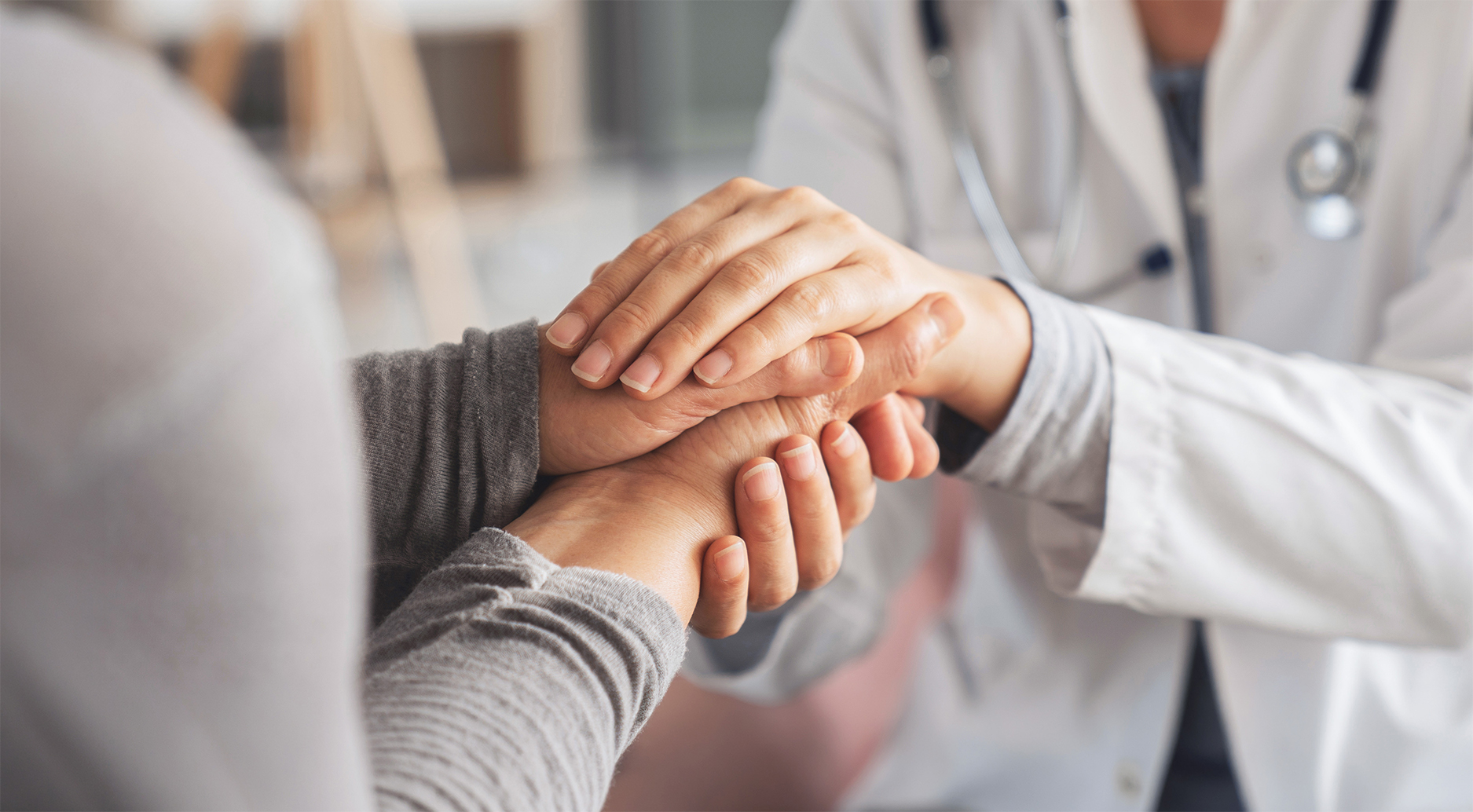 Lekarz trzyma pacjenta za rece