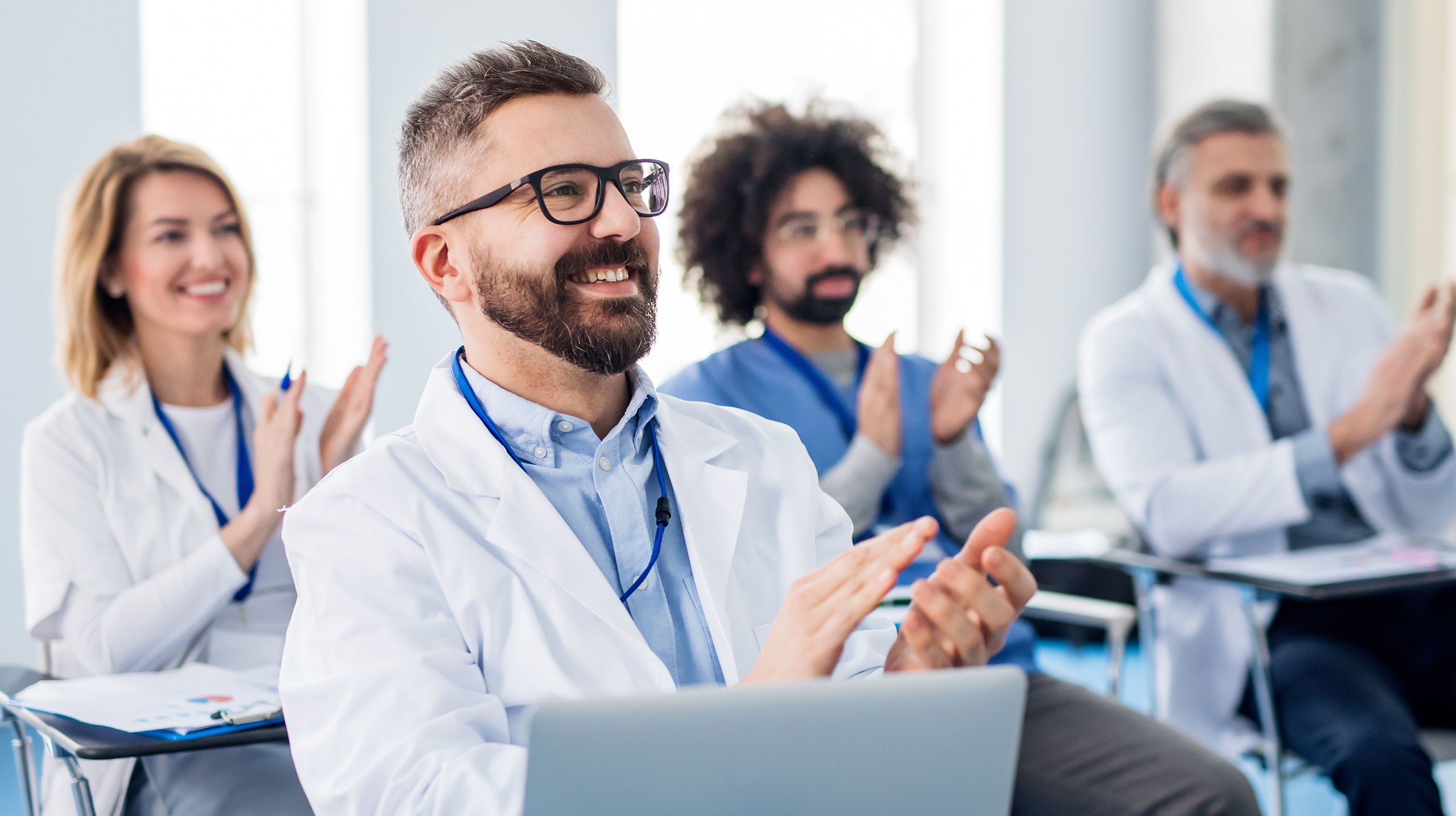 lekarze w kitlach na sali, klaszczą