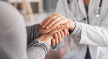 Lekarz trzyma pacjenta za rece